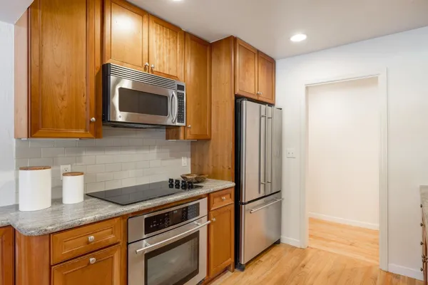 a kitchen with stainless steel appliances a stove microwave and refrigerator
