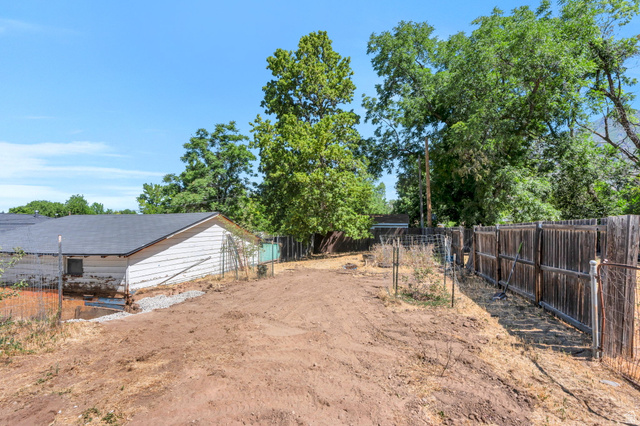 44 North 300 West Springville, UT 84663 - Photo 16 of 24 Expansive outdoor area featuring a cleared lot, mature trees, a wood fence, and a shed with a dark shingle roof