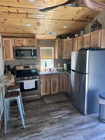 a kitchen with stainless steel appliances granite countertop a stove a refrigerator and a fireplace