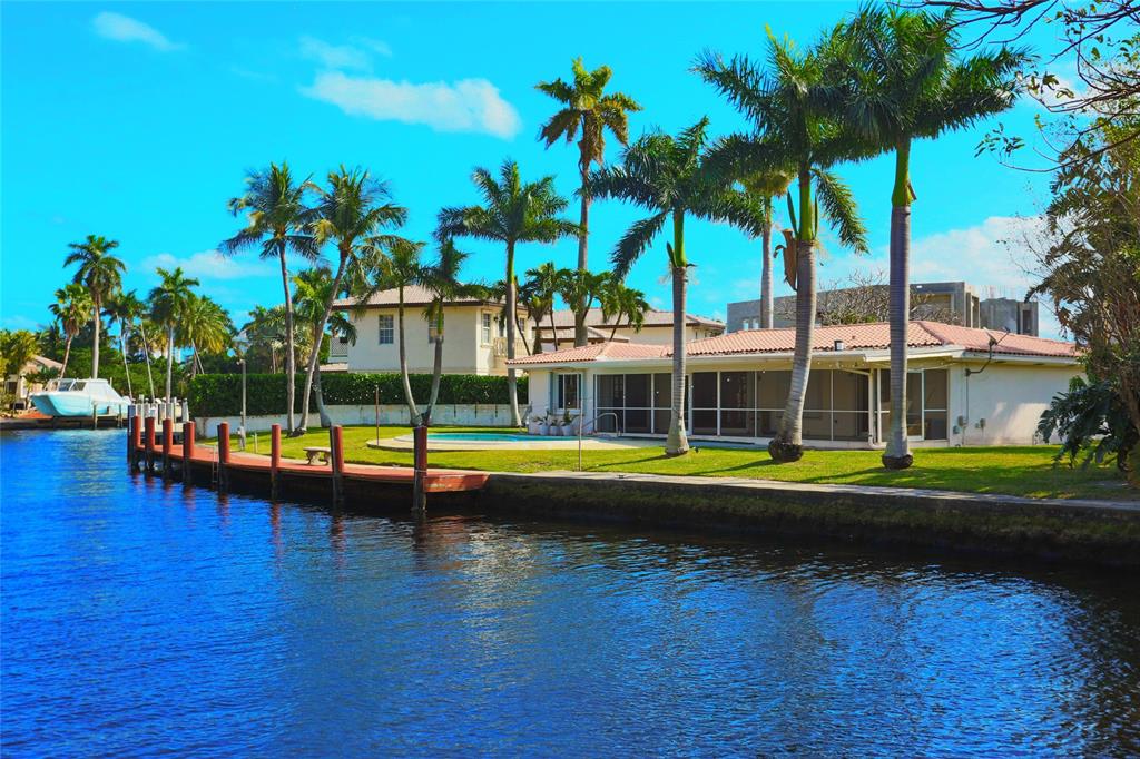 100 Circle Drive Pompano Beach, FL 33062 - Photo 1 of 30 a view of a swimming pool with a yard and palm trees