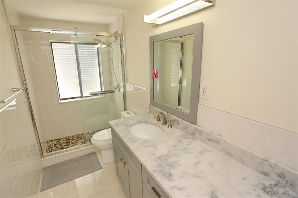 100 Circle Drive Pompano Beach, FL 33062 - Photo 15 of 30 a bathroom with a granite countertop sink a mirror and a toilet