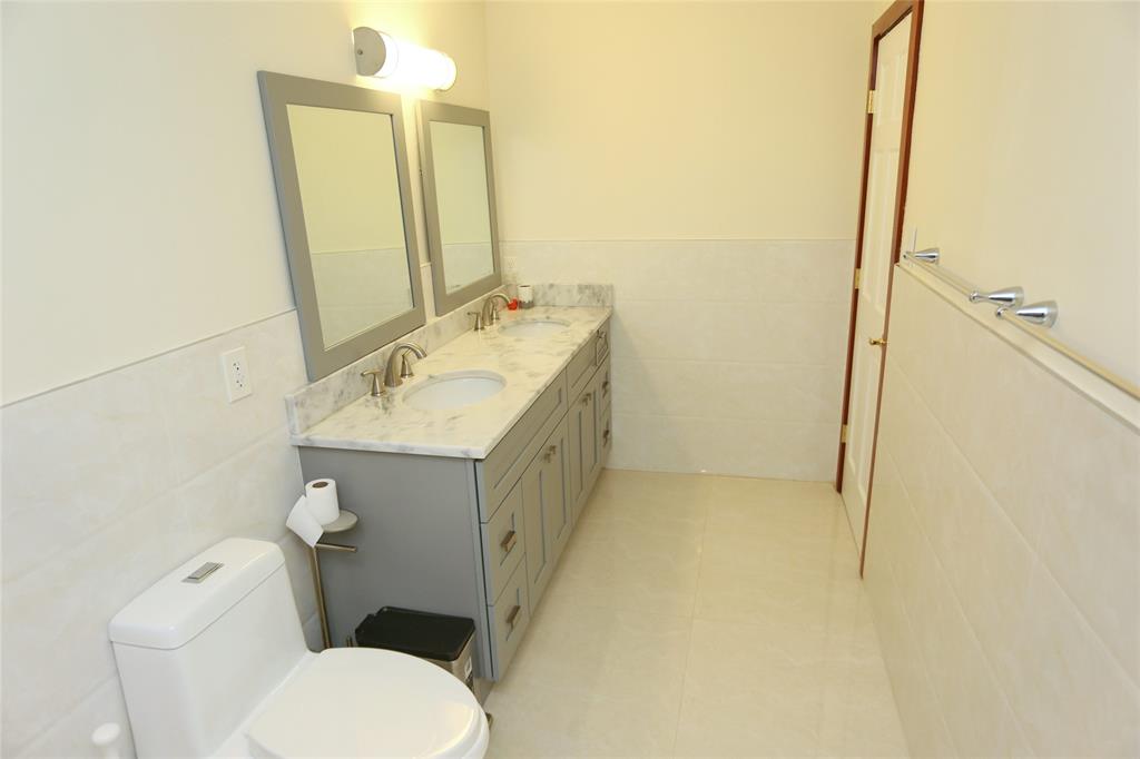 100 Circle Drive Pompano Beach, FL 33062 - Photo 17 of 30 a bathroom with a granite countertop toilet sink and mirror