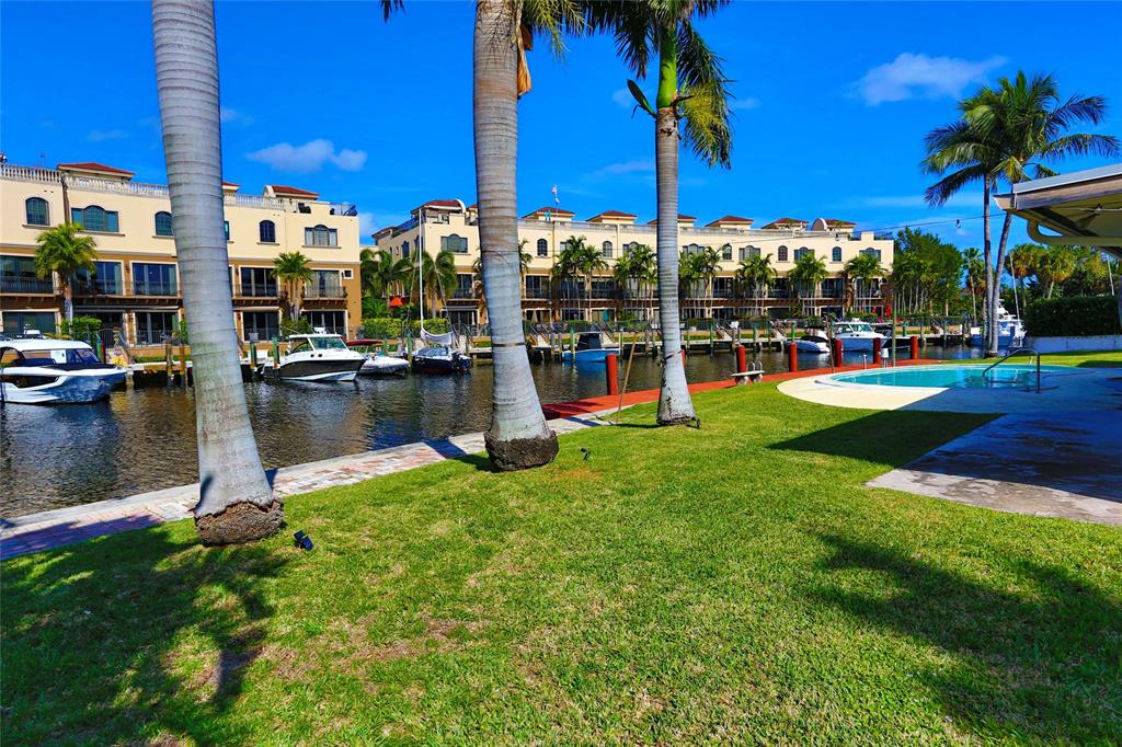 100 Circle Drive Pompano Beach, FL 33062 - Photo 23 of 30 a view of a swimming pool with a table and chairs