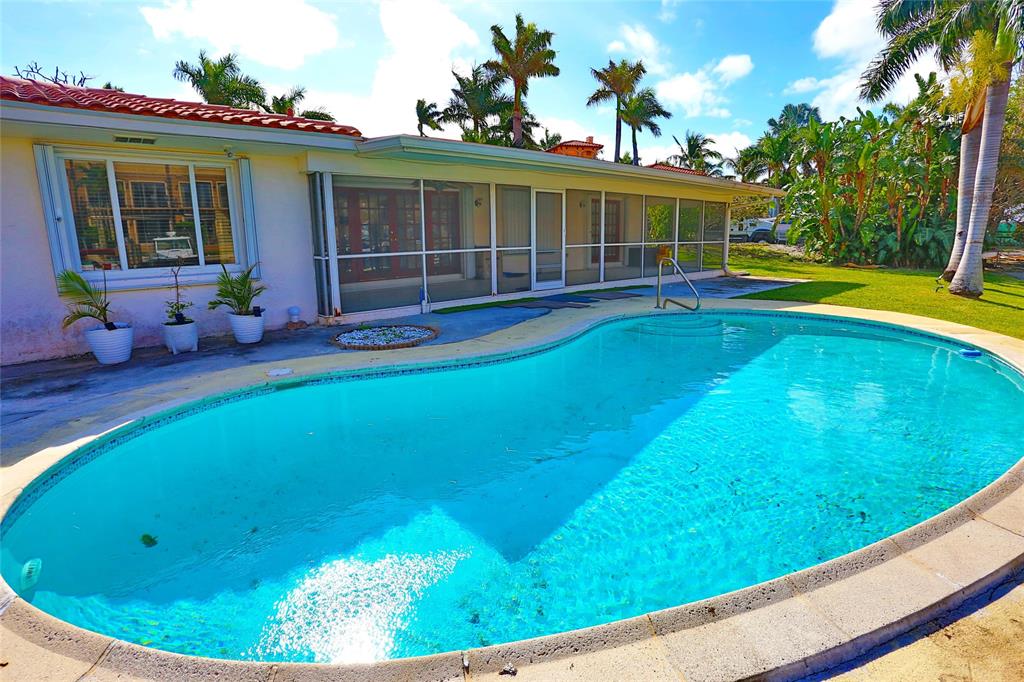 100 Circle Drive Pompano Beach, FL 33062 - Photo 24 of 30 a view of a house with a swimming pool and a yard