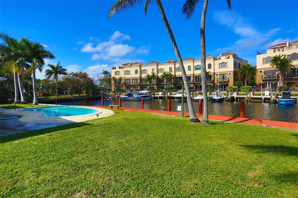 100 Circle Drive Pompano Beach, FL 33062 - Photo 29 of 30 a view of a swimming pool with a table and chairs under an umbrella