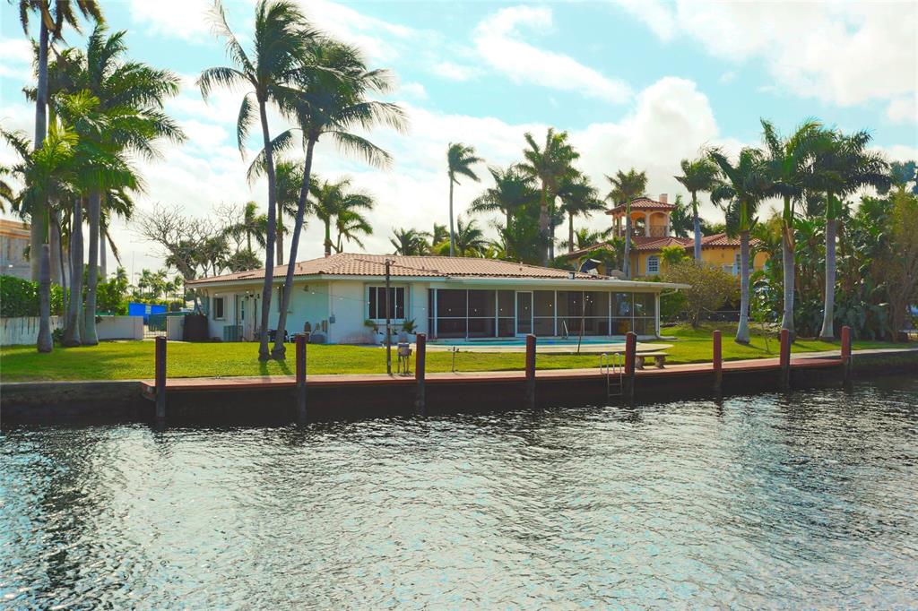 100 Circle Drive Pompano Beach, FL 33062 - Photo 30 of 30 a view of water swimming pool with a yard and palm trees