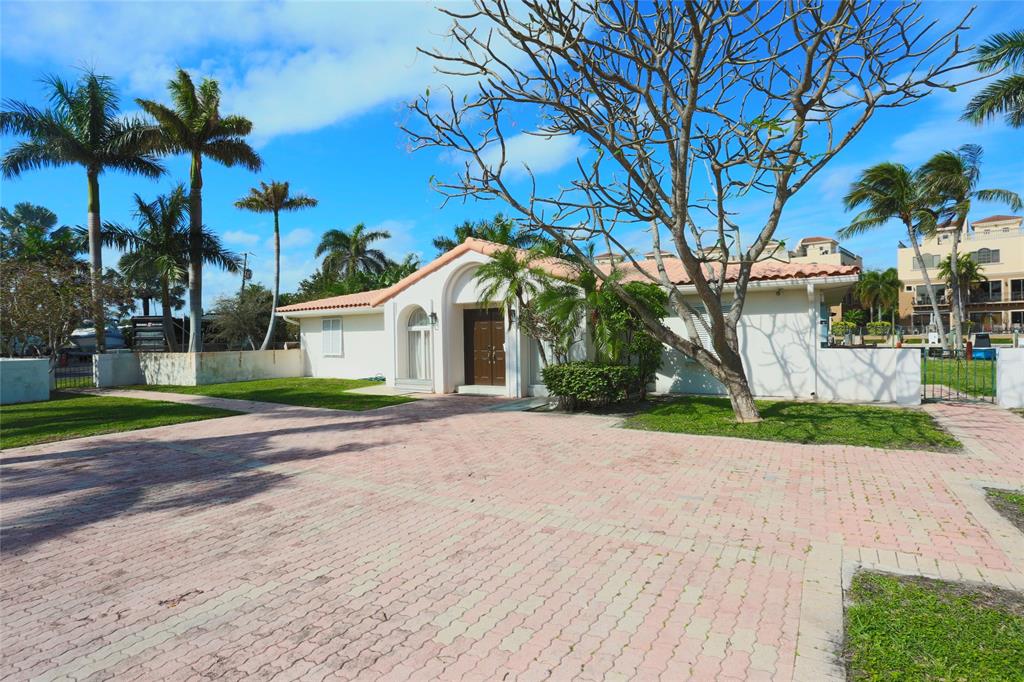 100 Circle Drive Pompano Beach, FL 33062 - Photo 3 of 30 a front view of a house with a yard and garage