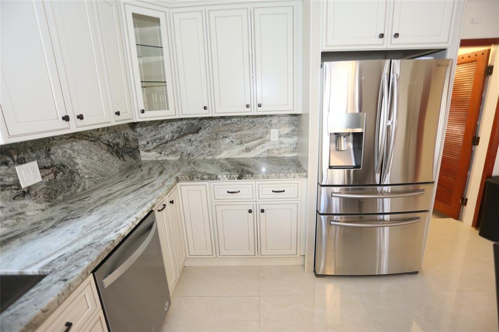 100 Circle Drive Pompano Beach, FL 33062 - Photo 9 of 30 a kitchen with stainless steel appliances granite countertop a refrigerator a stove and white cabinets