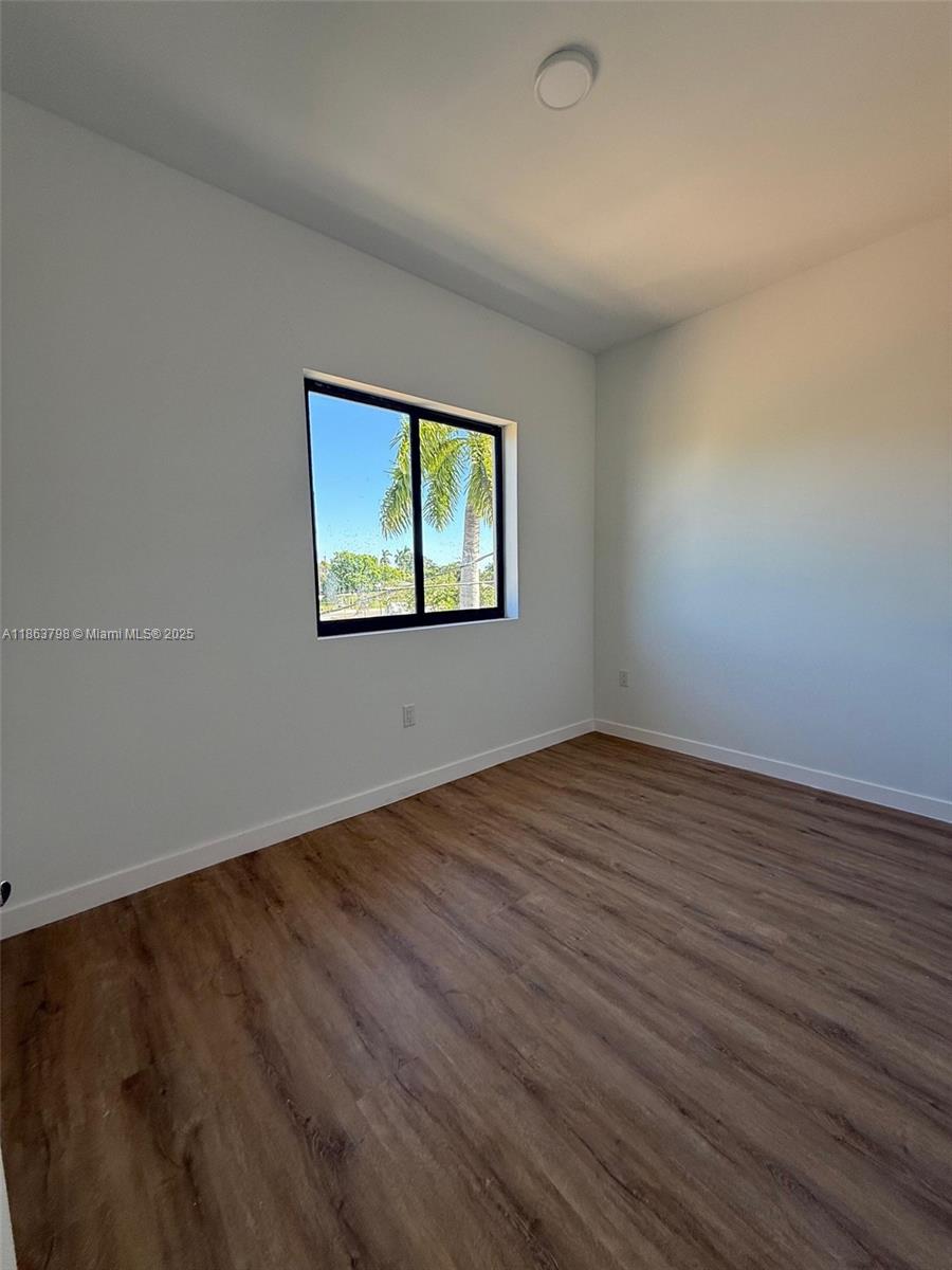 416 Southwest 1st Street, Unit 416 Florida City, FL 33034 - Photo 20 of 24 an empty room with wooden floor and windows