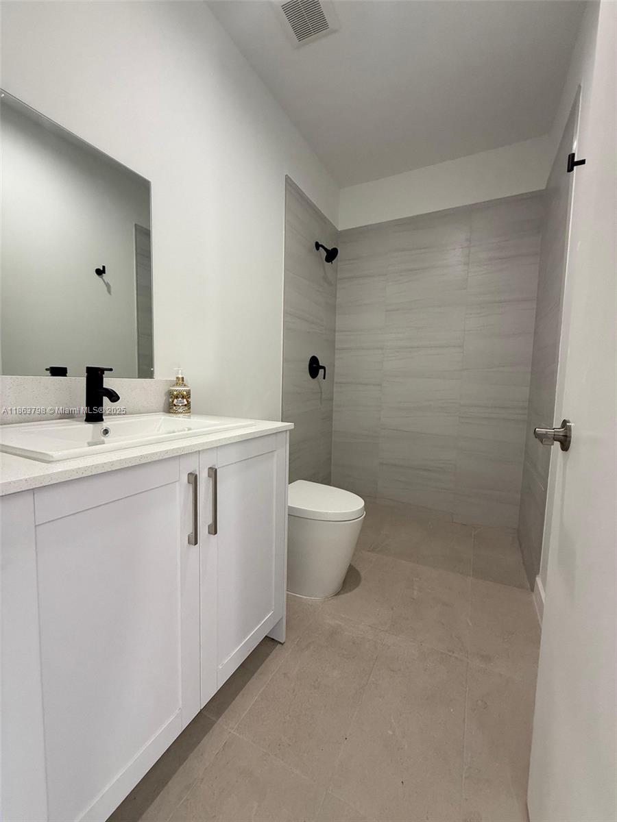 416 Southwest 1st Street, Unit 416 Florida City, FL 33034 - Photo 24 of 24 a white toilet sitting next to a bathroom sink