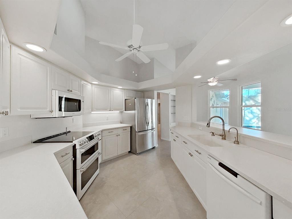 14595 Oliver Street Largo, FL 33774 - Photo 13 of 35 a large white kitchen with a stove a sink and a refrigerator