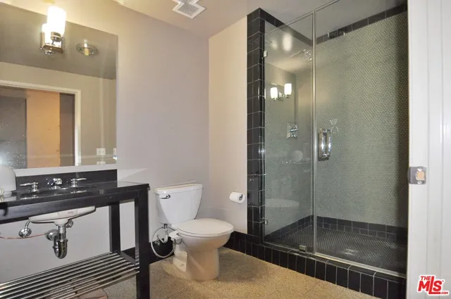 a bathroom with a shower a toilet and a sink