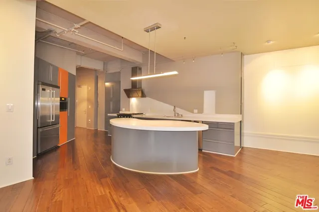 a view of kitchen with granite countertop a sink and a refrigerator