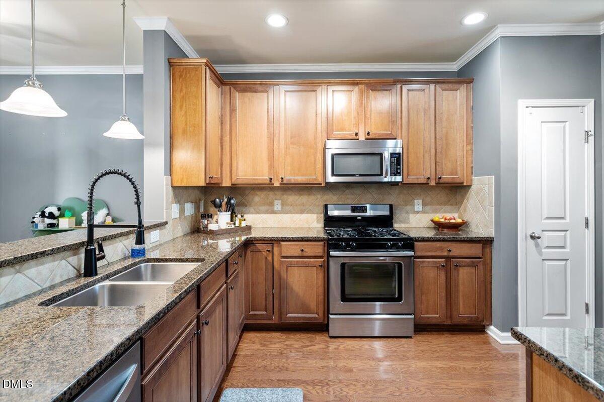 6224 Braidwood Court Raleigh, NC 27612 - Photo 13 of 39 a kitchen with stainless steel appliances granite countertop a sink and a stove