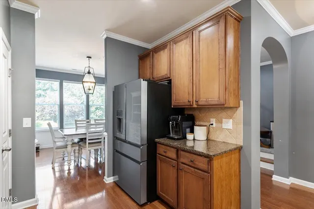 a kitchen with stainless steel appliances granite countertop a refrigerator a stove and a sink with granite countertops