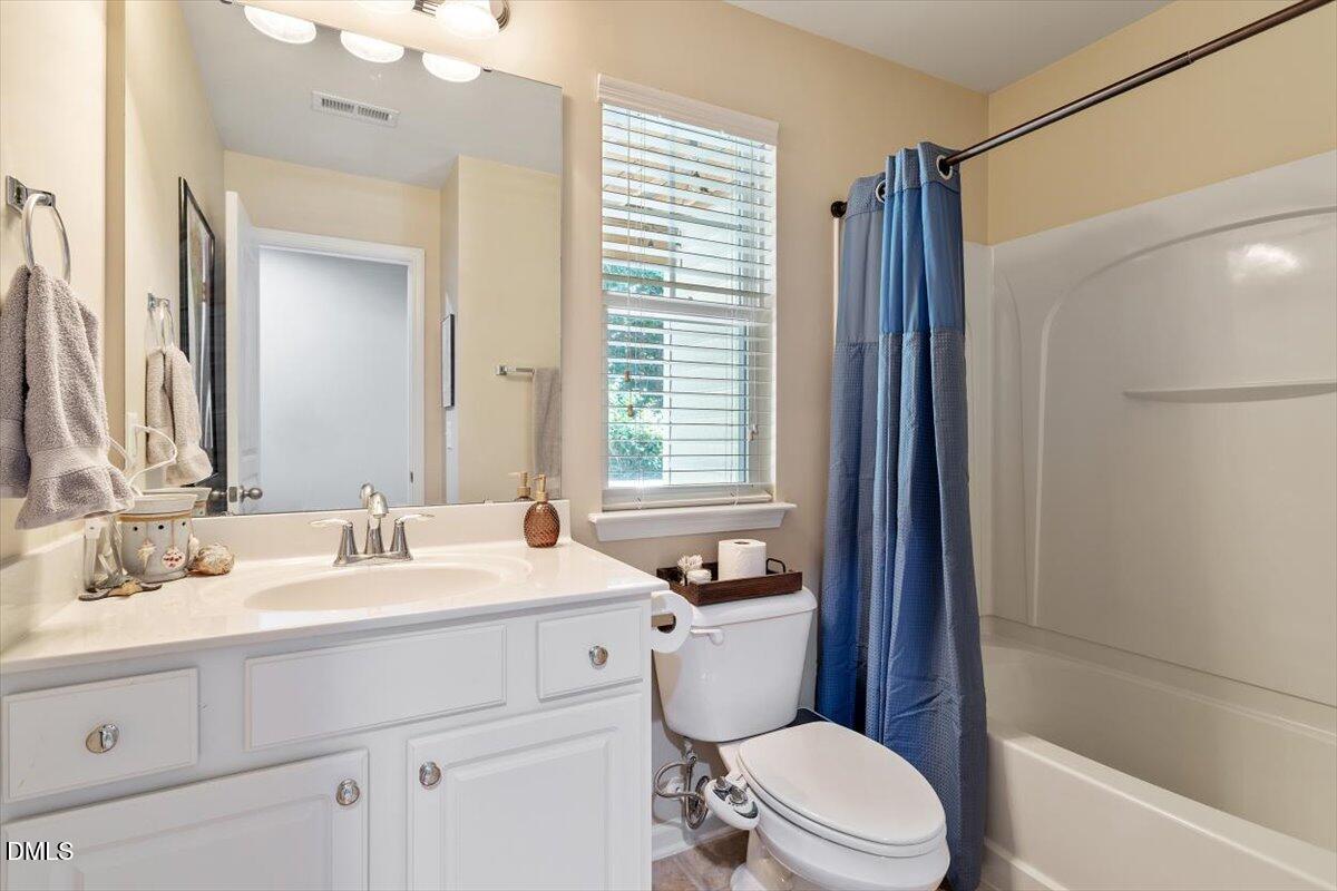 6224 Braidwood Court Raleigh, NC 27612 - Photo 19 of 39 a bathroom with a sink a toilet a mirror and shower