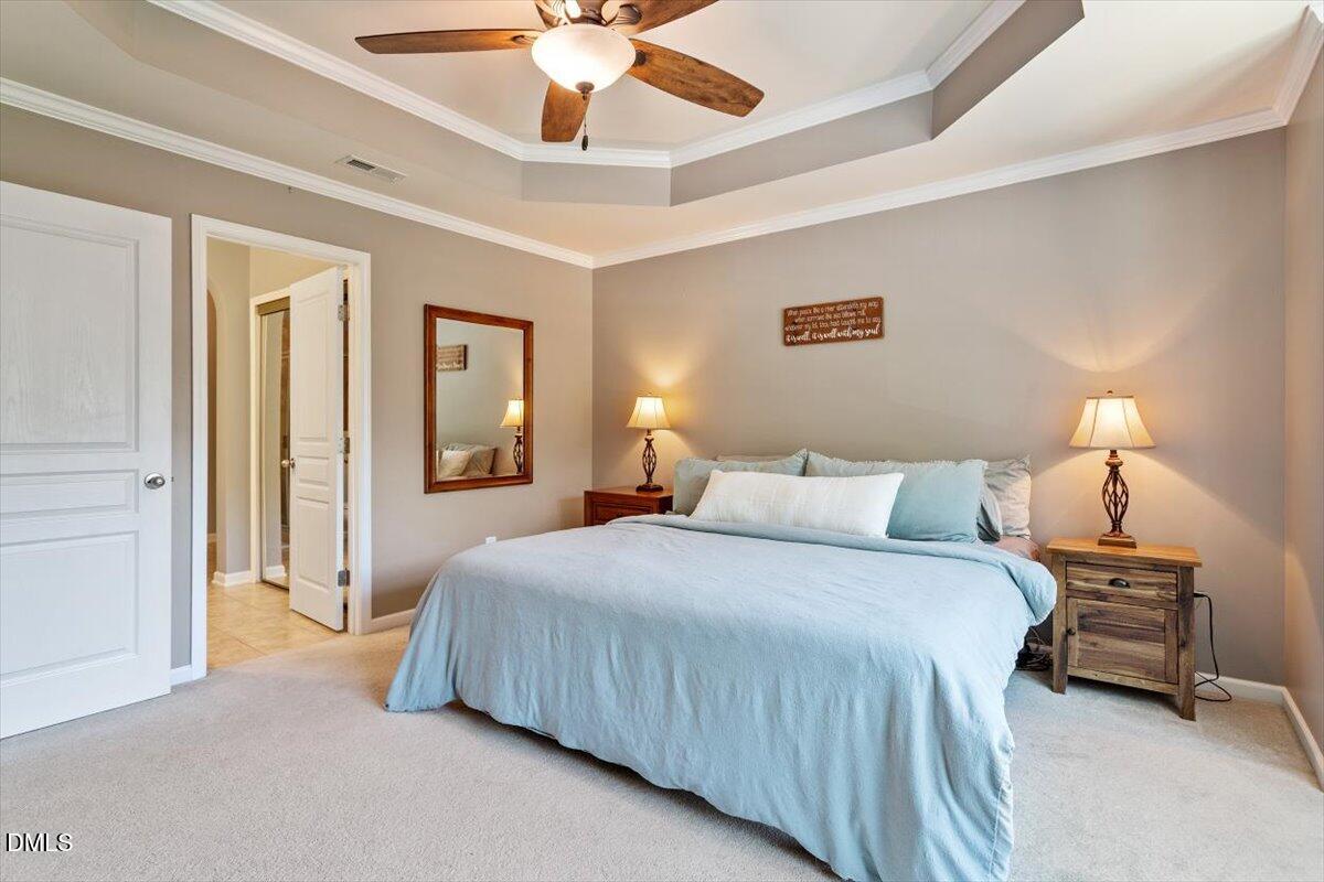 6224 Braidwood Court Raleigh, NC 27612 - Photo 24 of 39 a bedroom with a bed and a chandelier