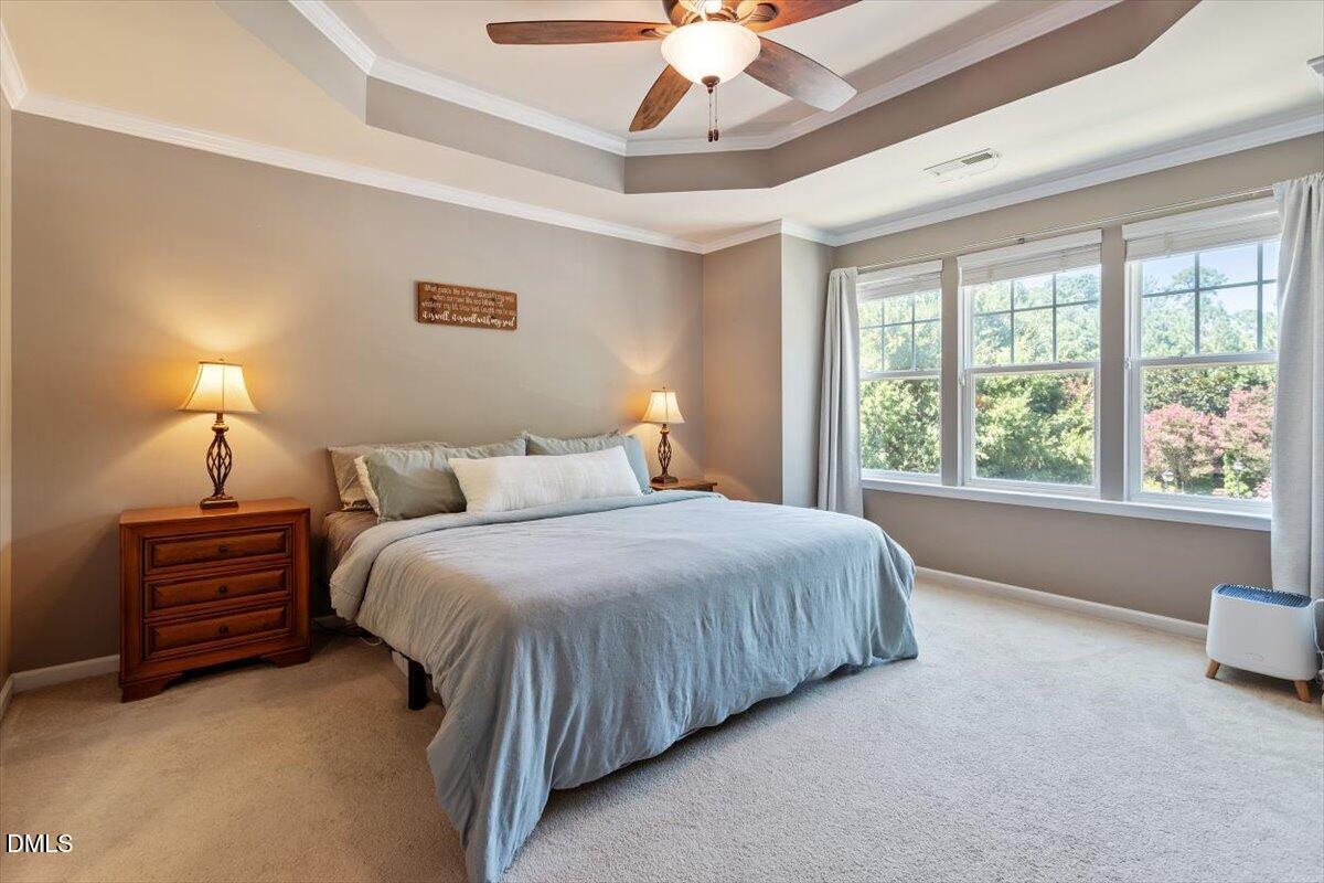 6224 Braidwood Court Raleigh, NC 27612 - Photo 25 of 39 a bedroom with a bed and a chandelier