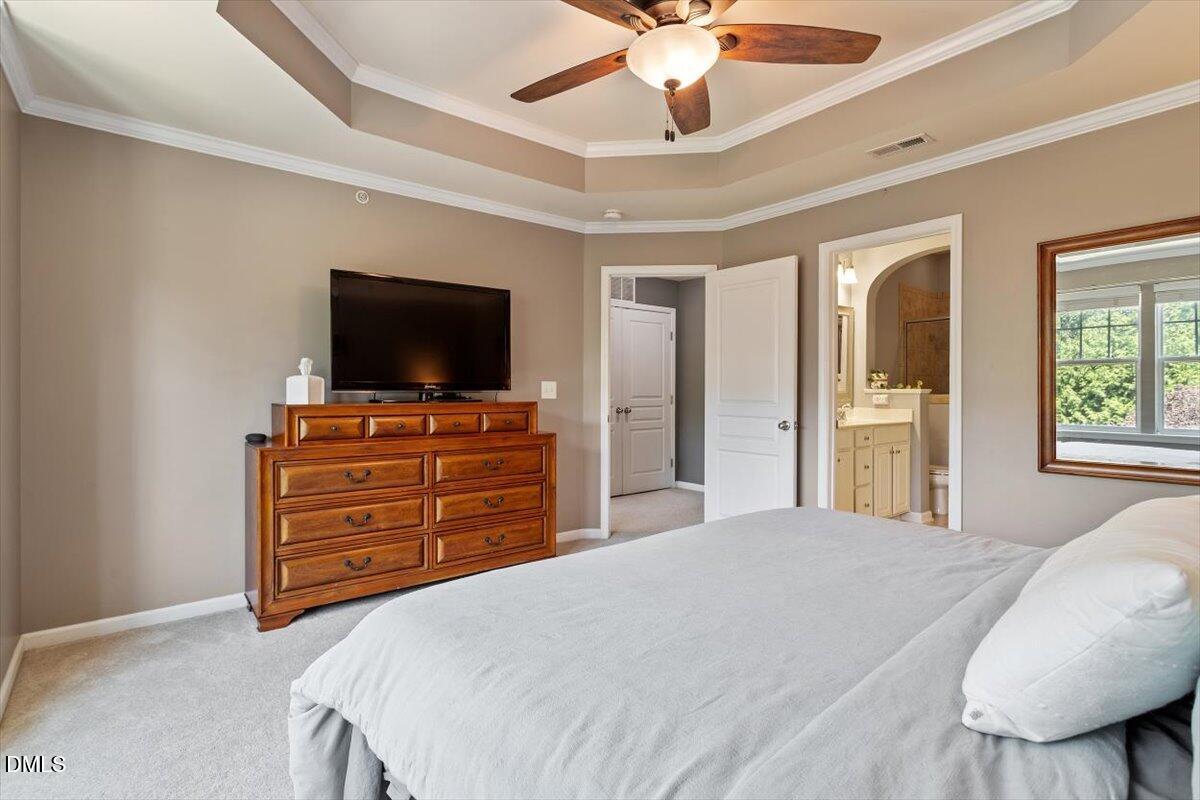 6224 Braidwood Court Raleigh, NC 27612 - Photo 26 of 39 a bedroom with a bed and a flat screen tv
