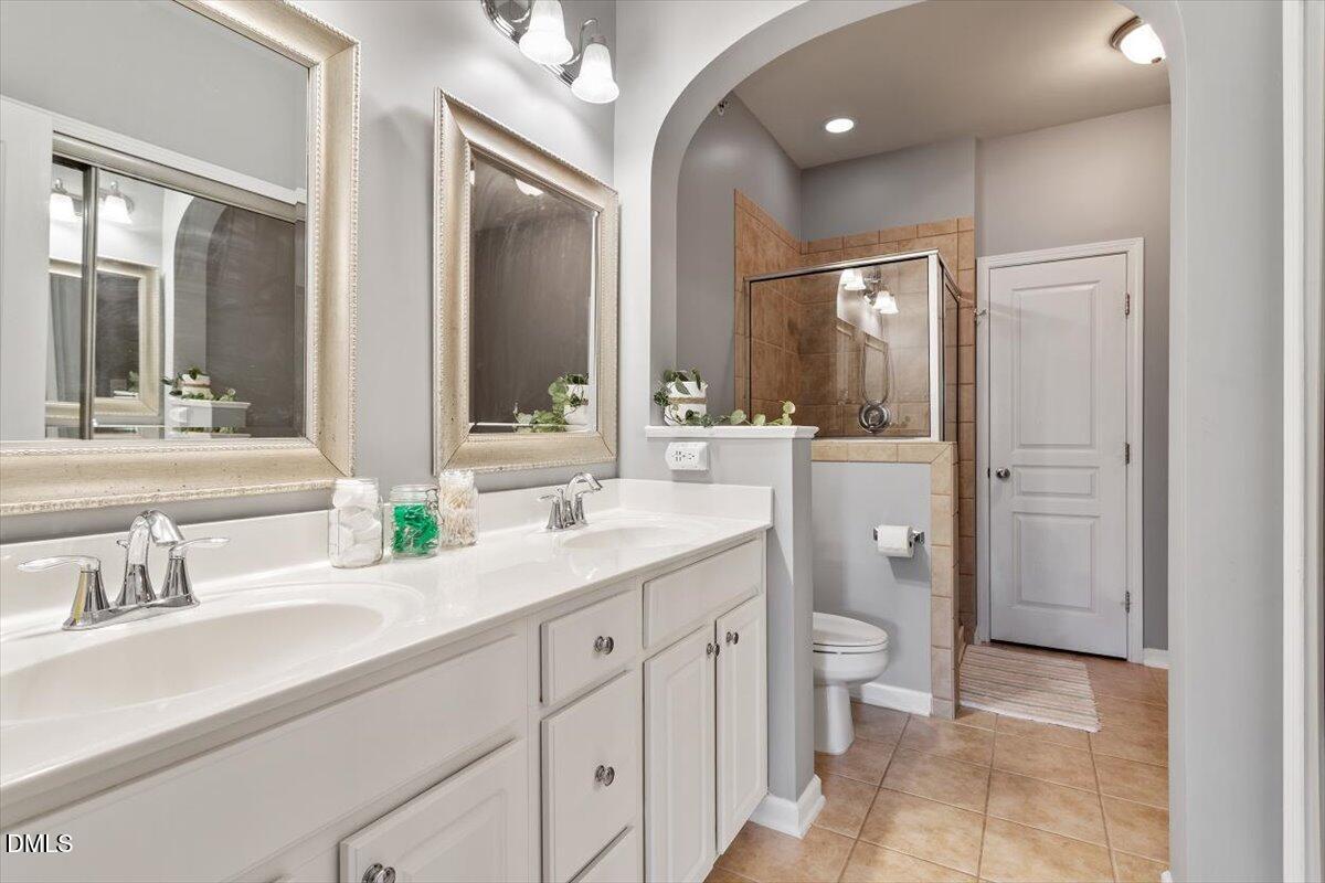 6224 Braidwood Court Raleigh, NC 27612 - Photo 27 of 39 a spacious bathroom with a granite countertop sink mirror and a toilet