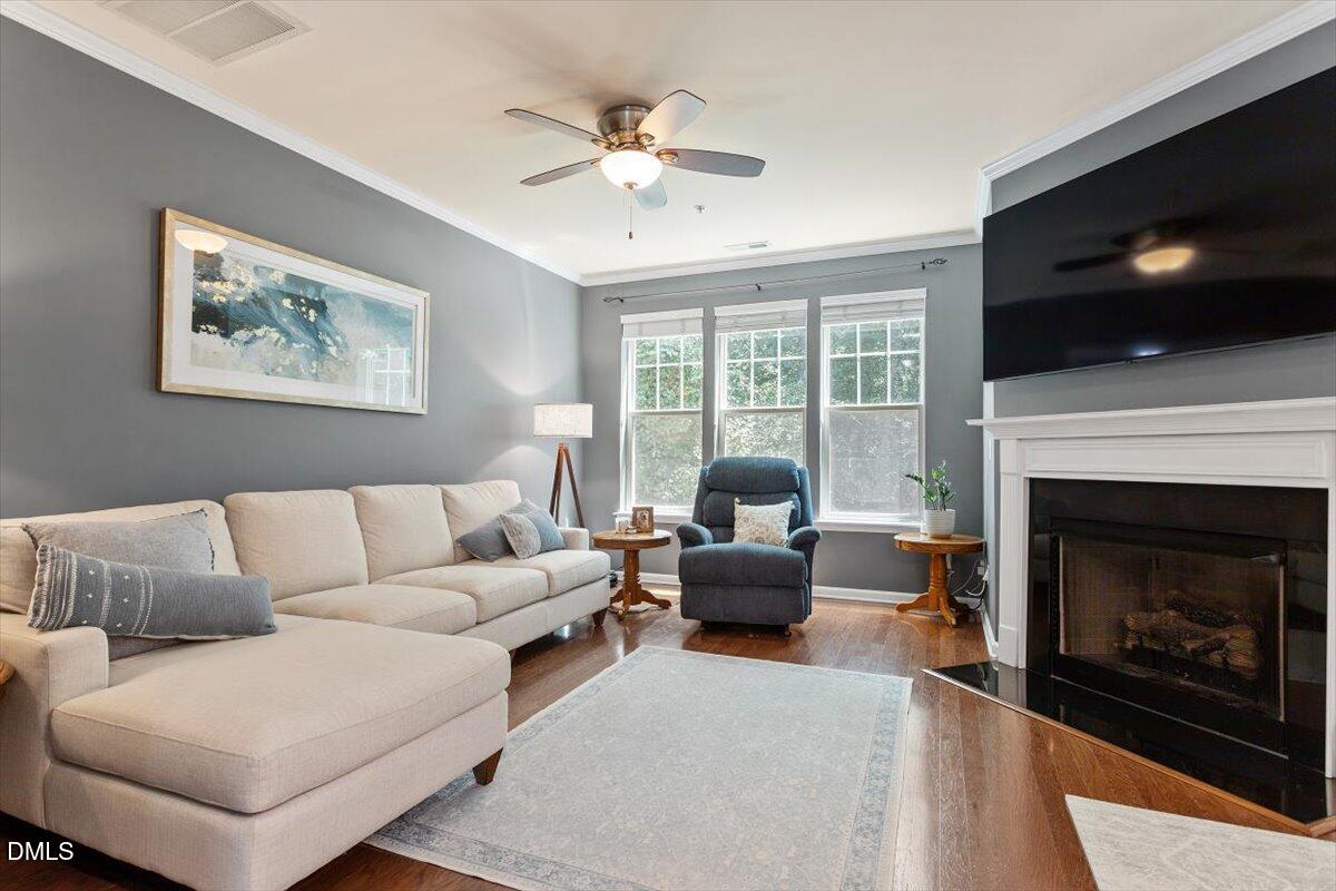 6224 Braidwood Court Raleigh, NC 27612 - Photo 6 of 39 a living room with furniture a flat screen tv and a fireplace