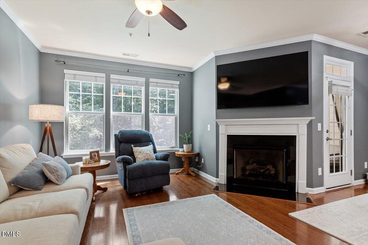 6224 Braidwood Court Raleigh, NC 27612 - Photo 7 of 39 a living room with furniture a flat screen tv and a fireplace