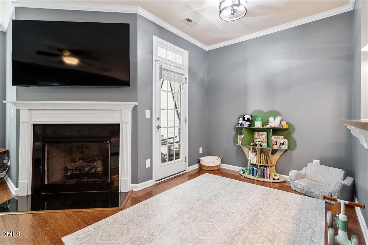 6224 Braidwood Court Raleigh, NC 27612 - Photo 10 of 39 a living room with a fireplace and a flat screen tv