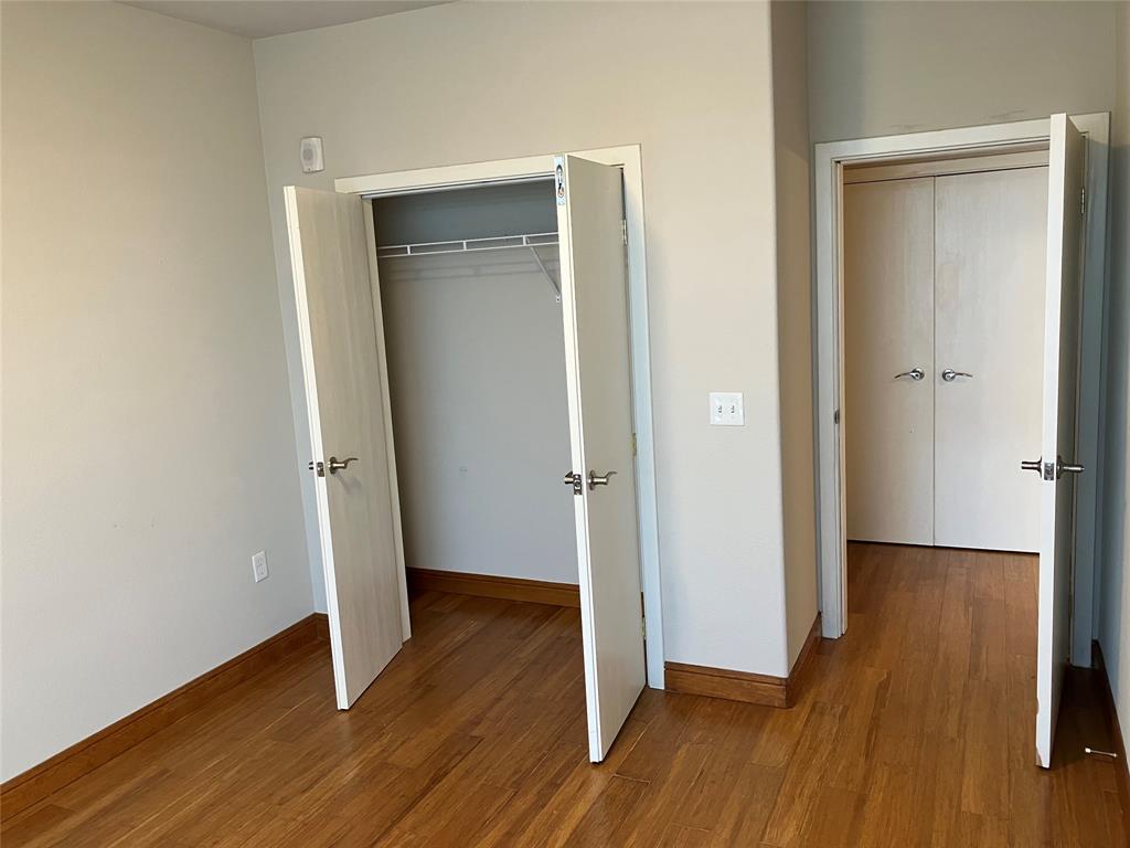 1220 West Trinity Mills Road, Unit 5009 Carrollton, TX 75006 - Photo 15 of 25 an empty room with wooden floor and entrance