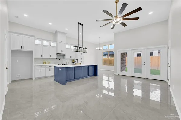 a large kitchen with stainless steel appliances kitchen island granite countertop a stove a sink a refrigerator and a view of living room
