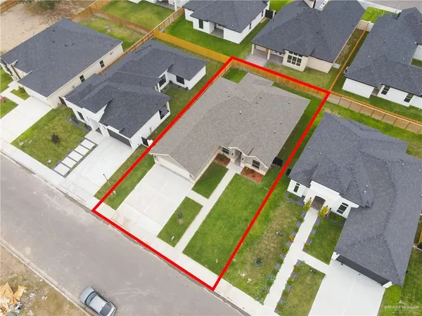an aerial view of residential houses with outdoor space and parking