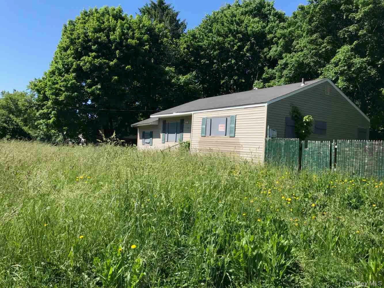 848 Station Road Bellport, NY 11713 - Photo 2 of 4 a backyard of a house with table and chairs under an umbrella