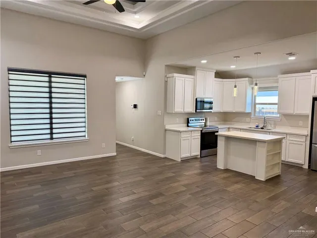 a large white kitchen with white cabinets and a sink