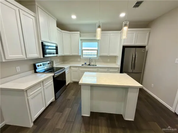a kitchen with a sink a stove a refrigerator and cabinets