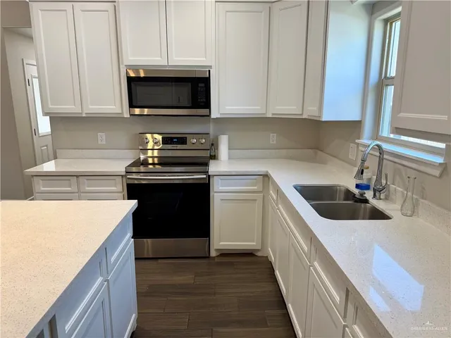 a kitchen with a sink stove and microwave