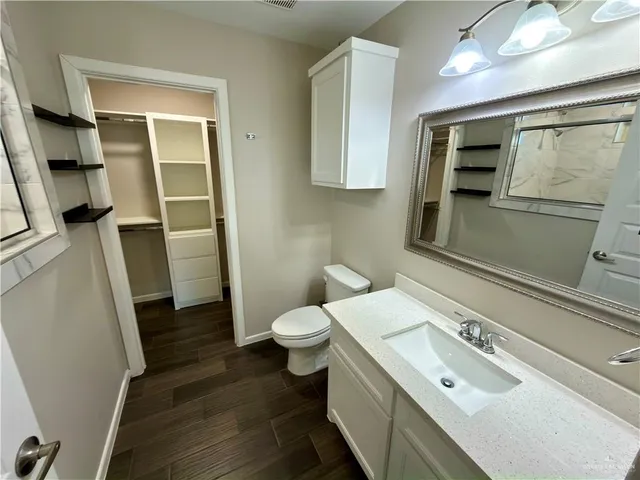 a bathroom with a sink a toilet and mirror