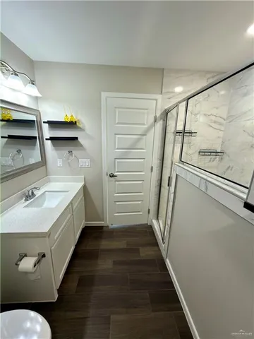a bathroom with a sink a toilet and shower