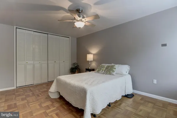 a spacious bedroom with a bed and a chandelier