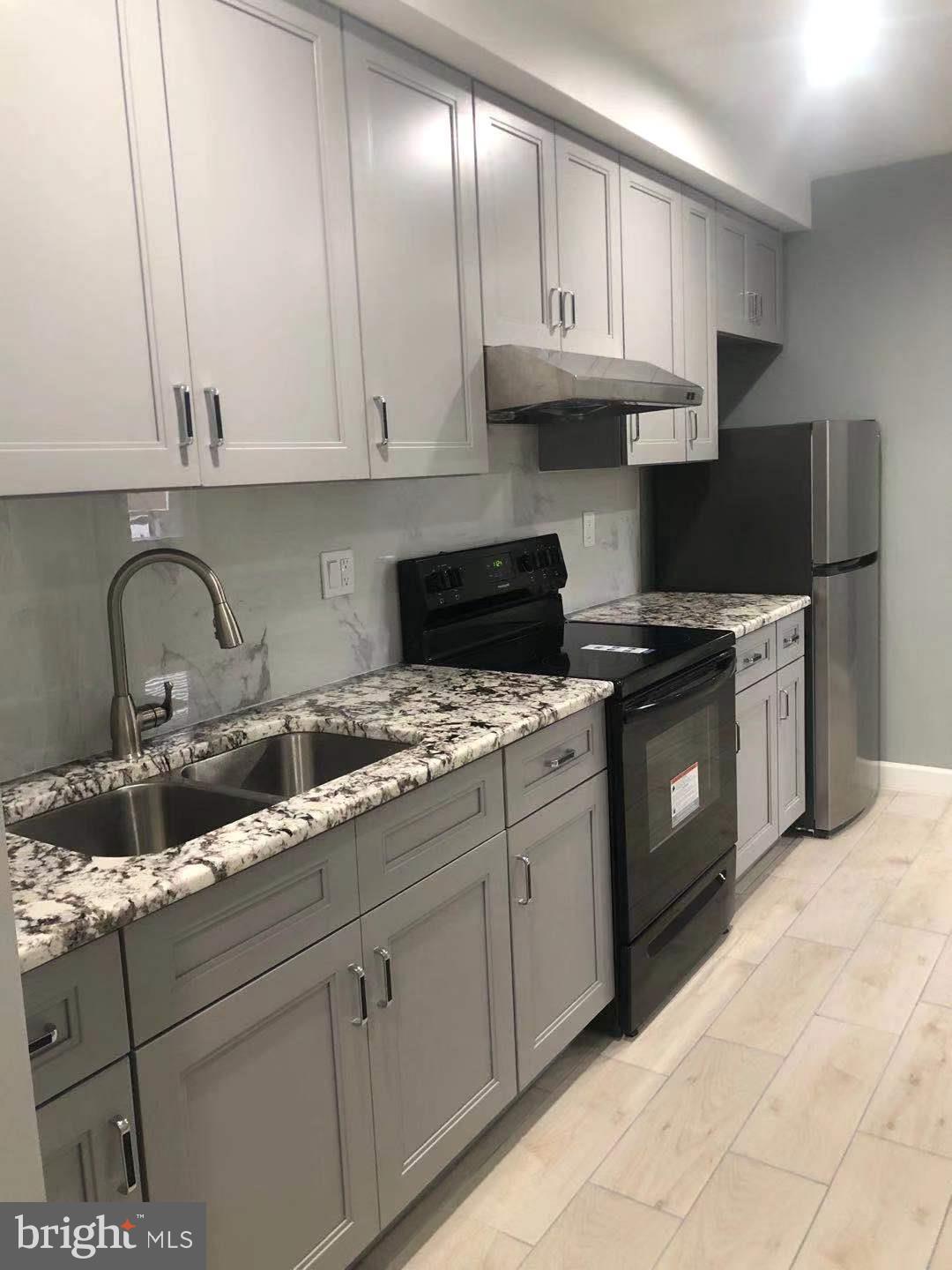 a kitchen with granite countertop a sink stainless steel appliances and cabinets