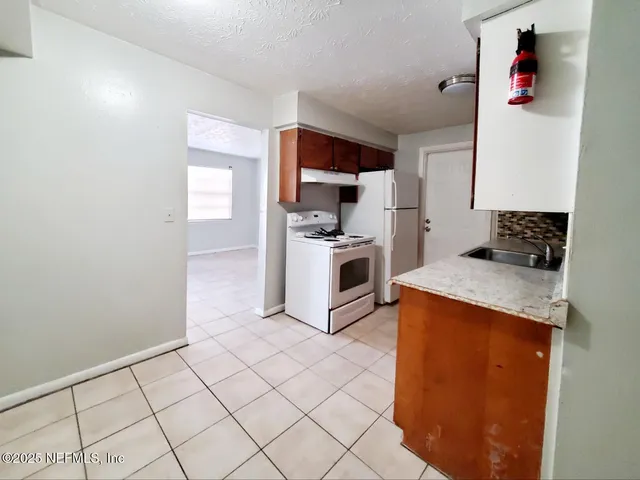 a kitchen with a stove a sink and a refrigerator