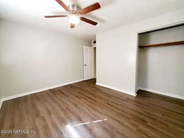 a view of an empty room with wooden floor