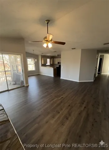 a view of a room with wooden floor fireplace and window