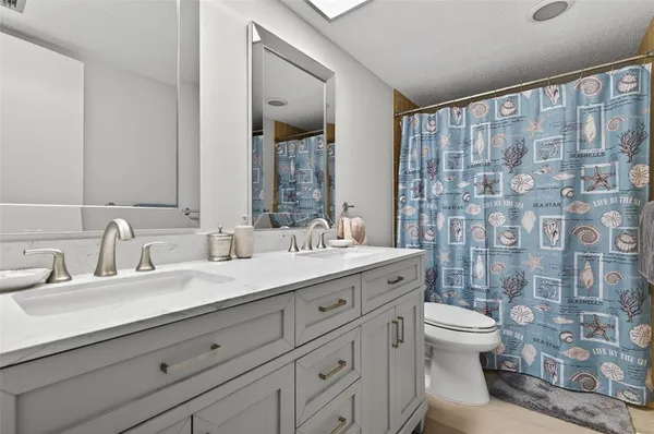 a bathroom with a double vanity sink toilet and shower