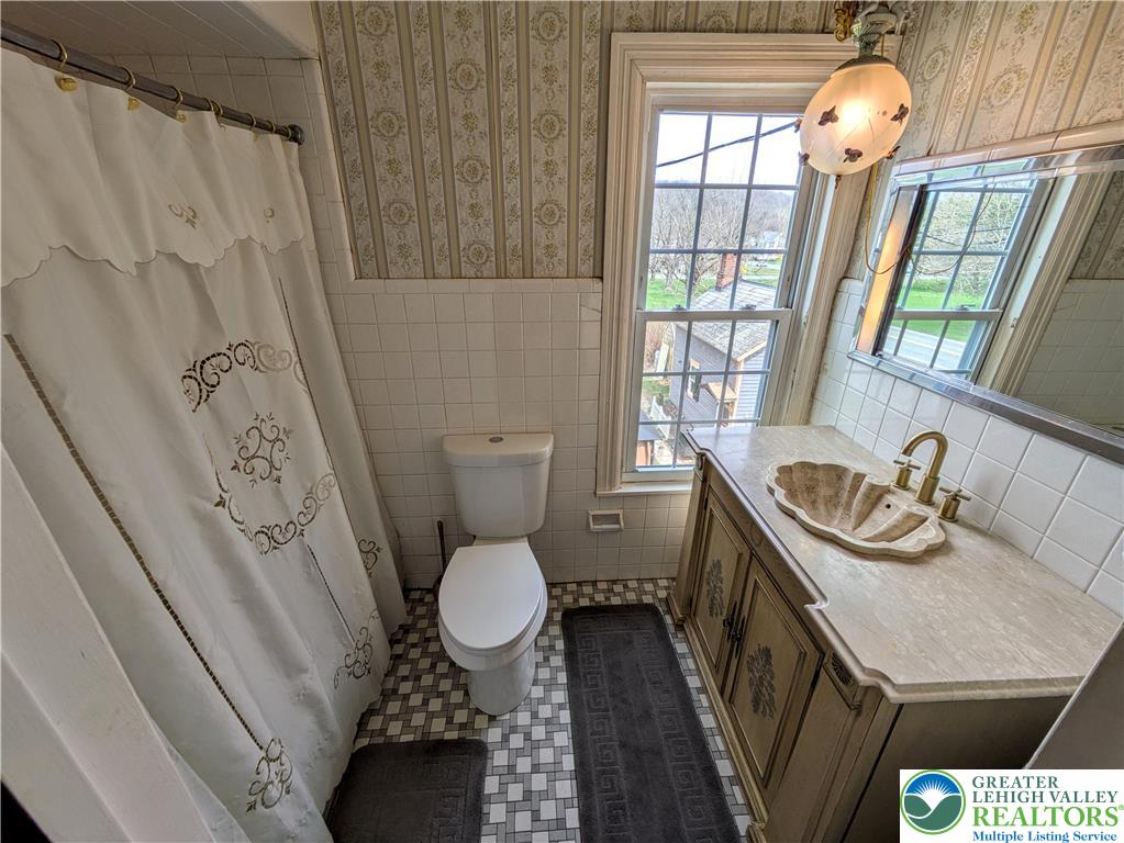 6423 Front Street Bangor, PA 18013 - Photo 39 of 60 a bathroom with a granite countertop sink toilet a mirror and a tub