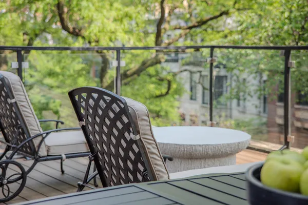 a view of a balcony with chairs and a potted plant