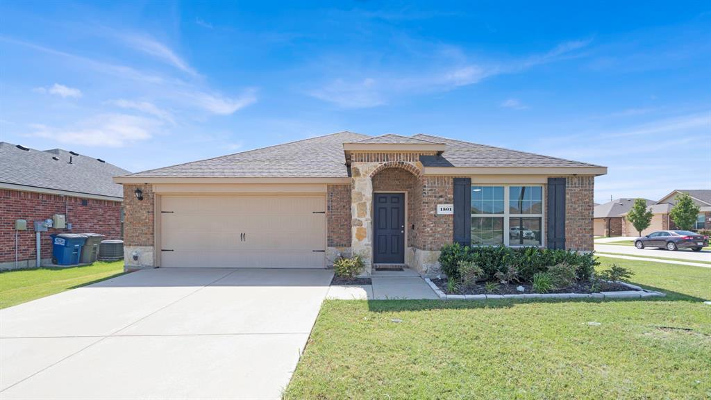 a view of a white house next to a yard with potted plants
