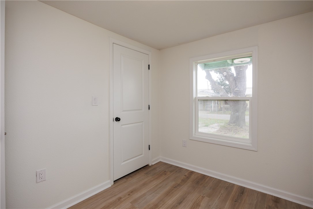 306 Allison Drive Gregory, TX 78359 - Photo 13 of 27 an empty room with wooden floor and windows