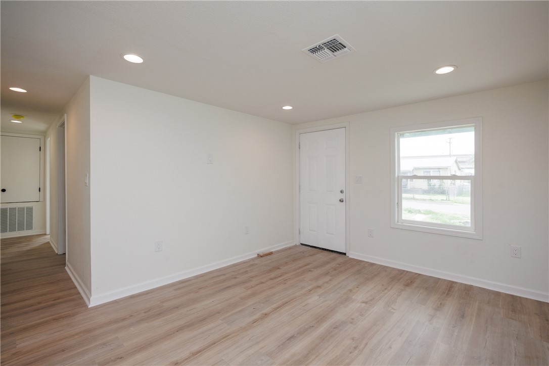 306 Allison Drive Gregory, TX 78359 - Photo 4 of 27 an empty room with wooden floor and windows