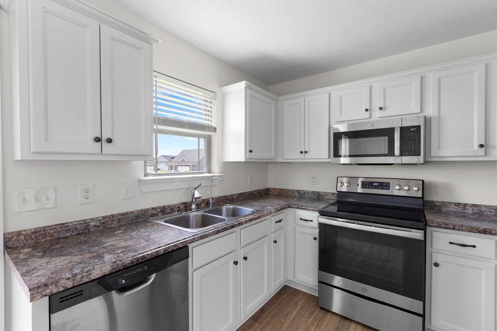 408 Brigade Court Lebanon, TN 37087 - Photo 11 of 36 a kitchen with granite countertop white cabinets appliances a sink and a window