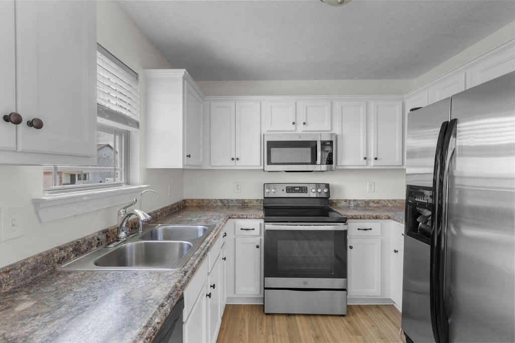 408 Brigade Court Lebanon, TN 37087 - Photo 12 of 36 a kitchen with white cabinets sink and stainless steel appliances