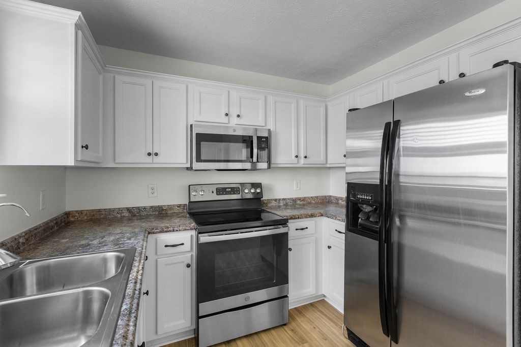 408 Brigade Court Lebanon, TN 37087 - Photo 13 of 36 a kitchen with granite countertop white cabinets and stainless steel appliances